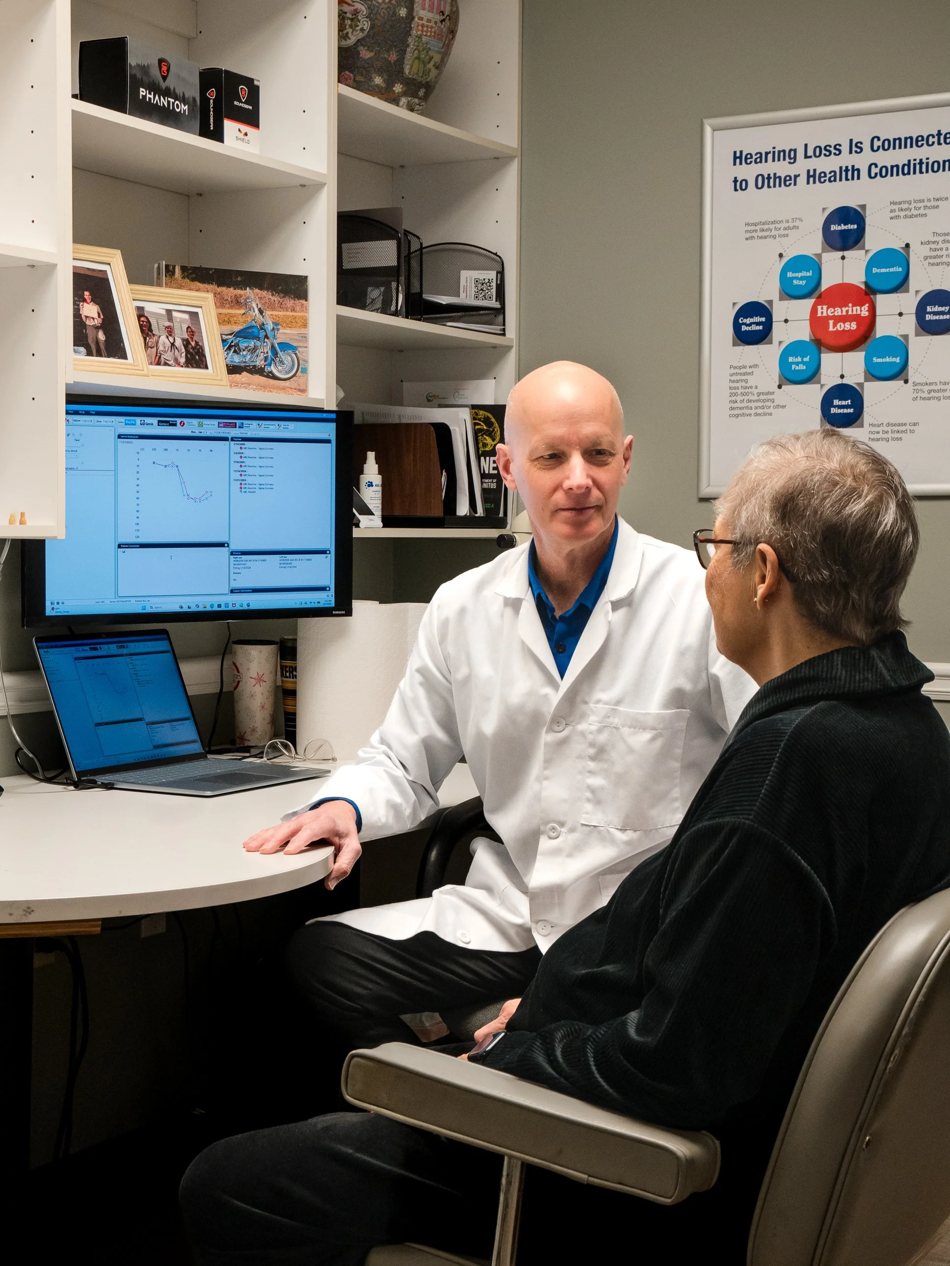 Keith in a desk-side consultation with a patient at Aurilink