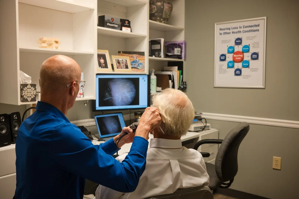 A hearing device checked at the ear during a video otoscopy exam at Aurilink