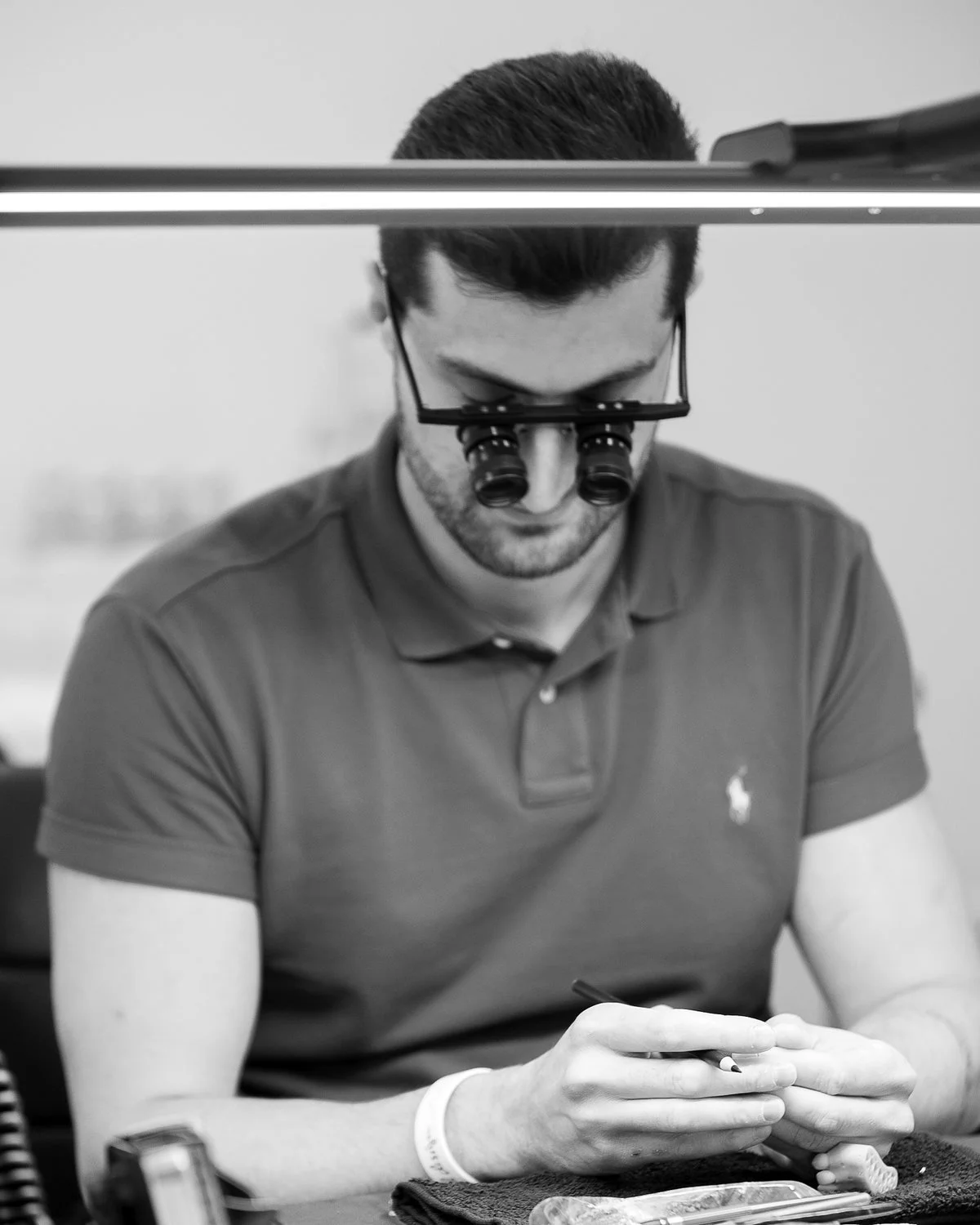 Mst. Moe Khalili, Zahntechnikermeister in Graz, konzentriert bei der Arbeit mit Lupenbrille