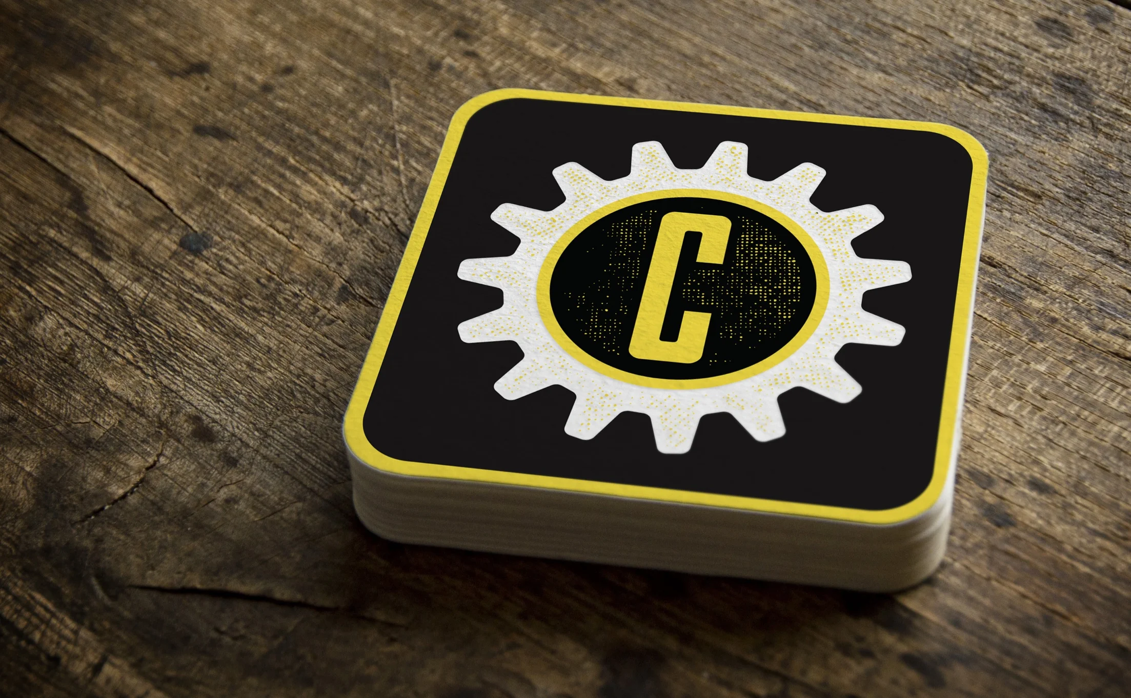 Cranker's Brewery gear icon printed on a stack of coasters