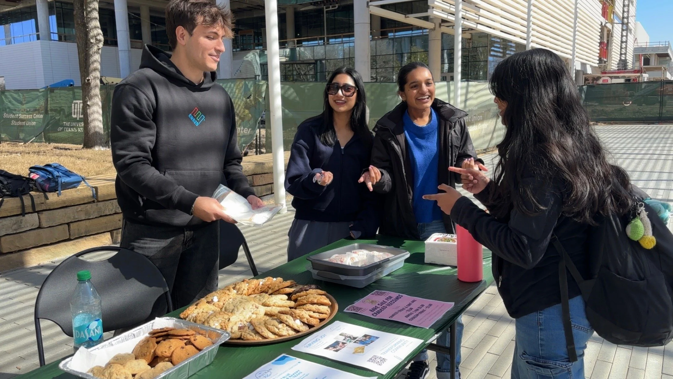 Cradled Blessings members talking with students at a campus bake sale