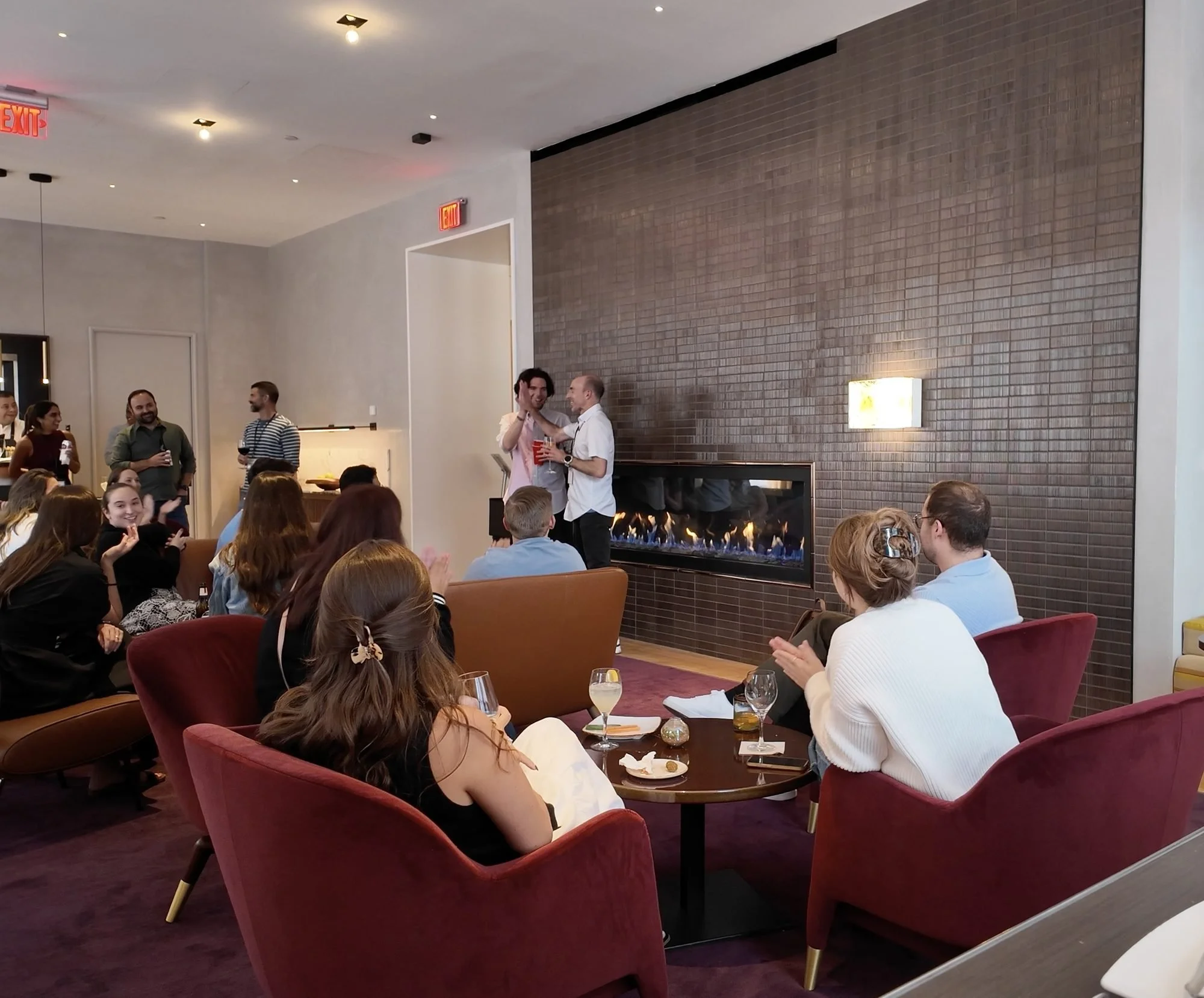 Seated guests watching and applauding a parlor magic show at a private event