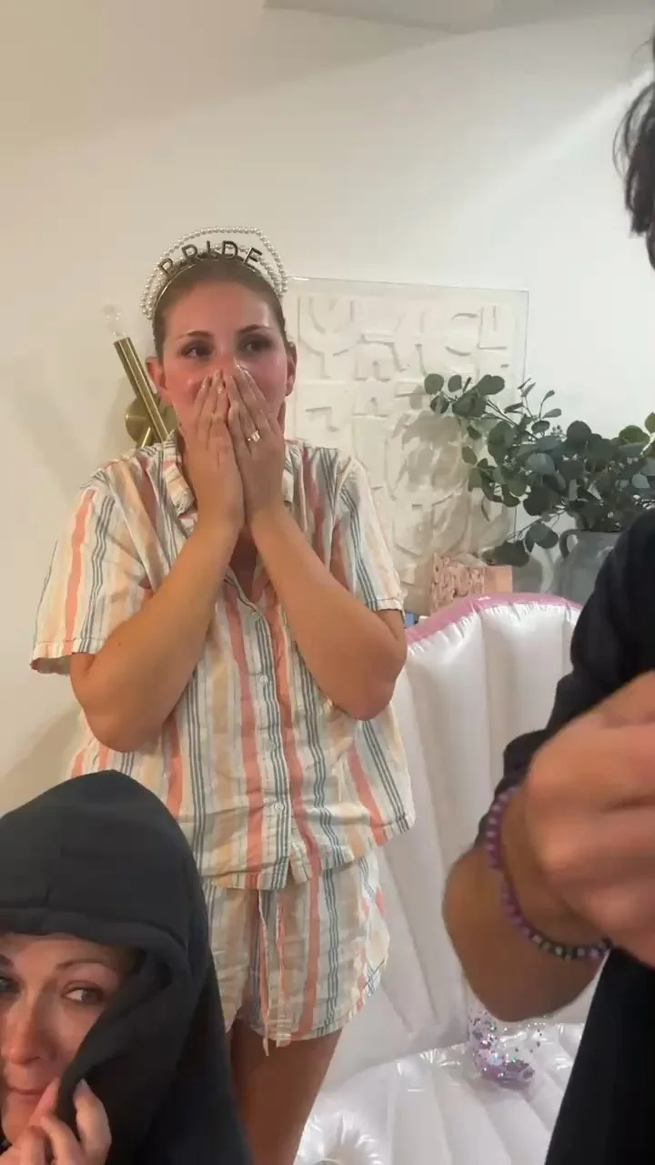 Bride wearing a bride headband reacting in disbelief during a bachelorette party magic show