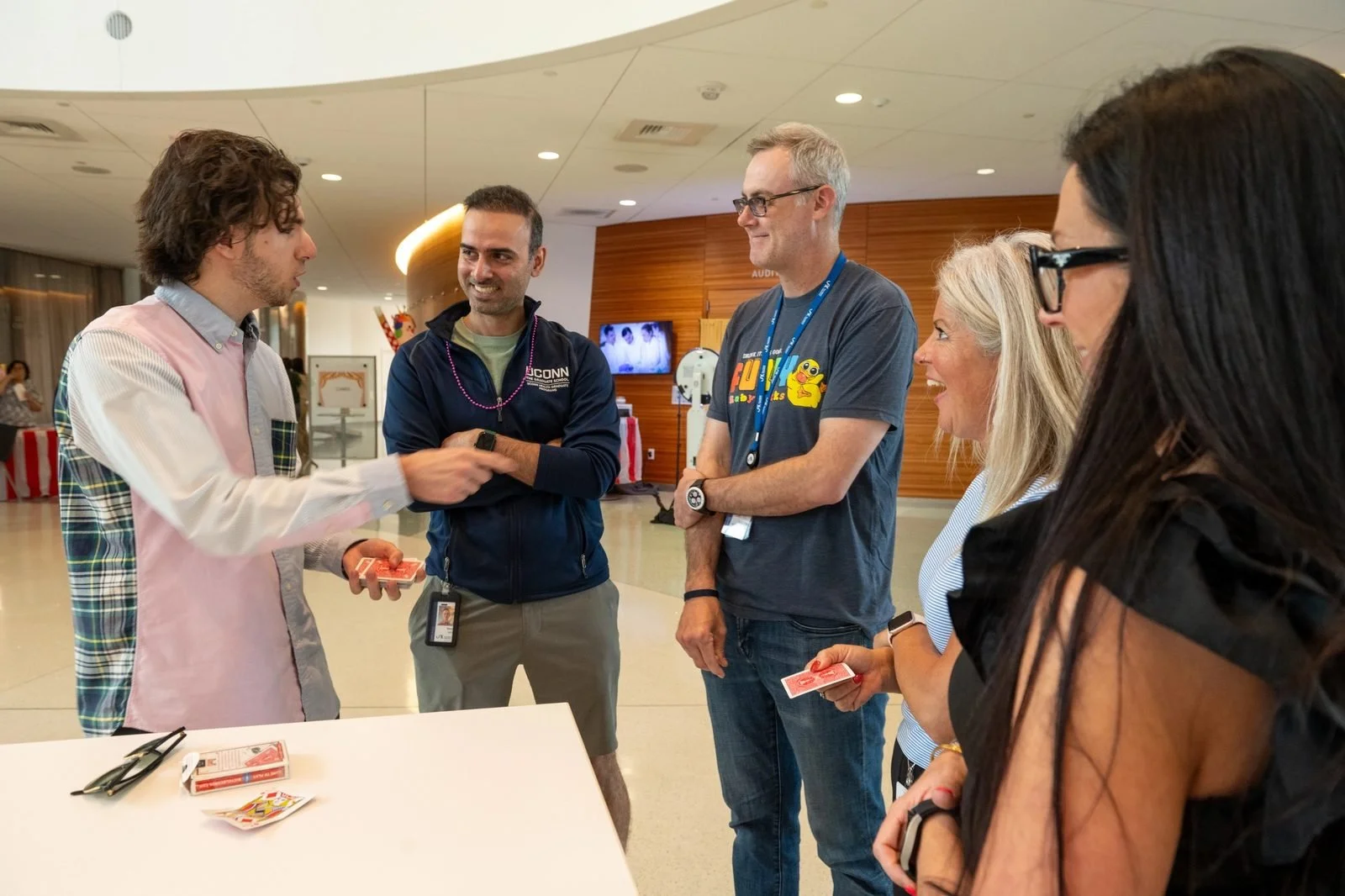 Corporate magician performing close-up card magic for a group of employees at a Connecticut company event