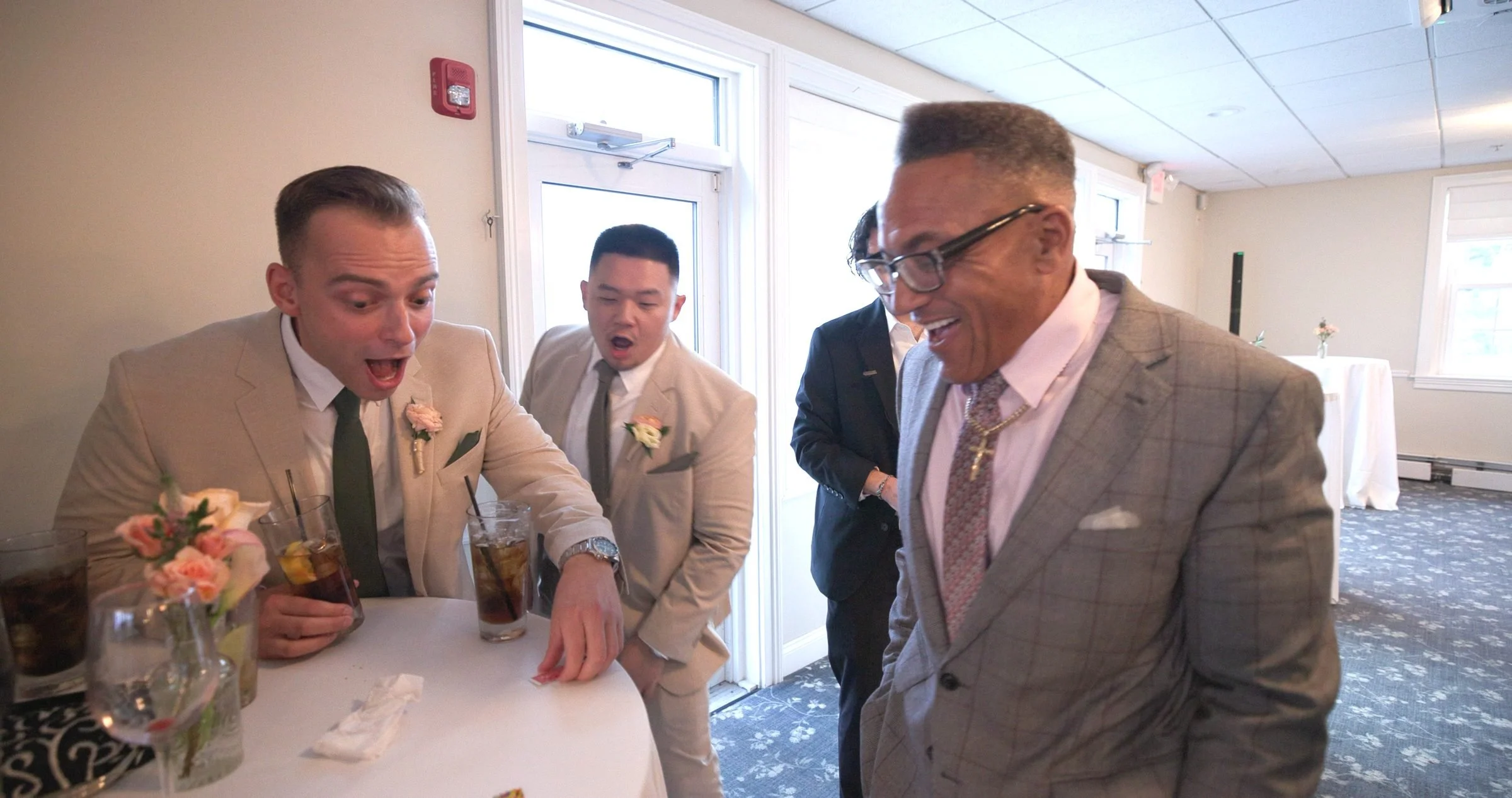 Groom and groomsmen reacting to a card reveal at a Rhode Island wedding