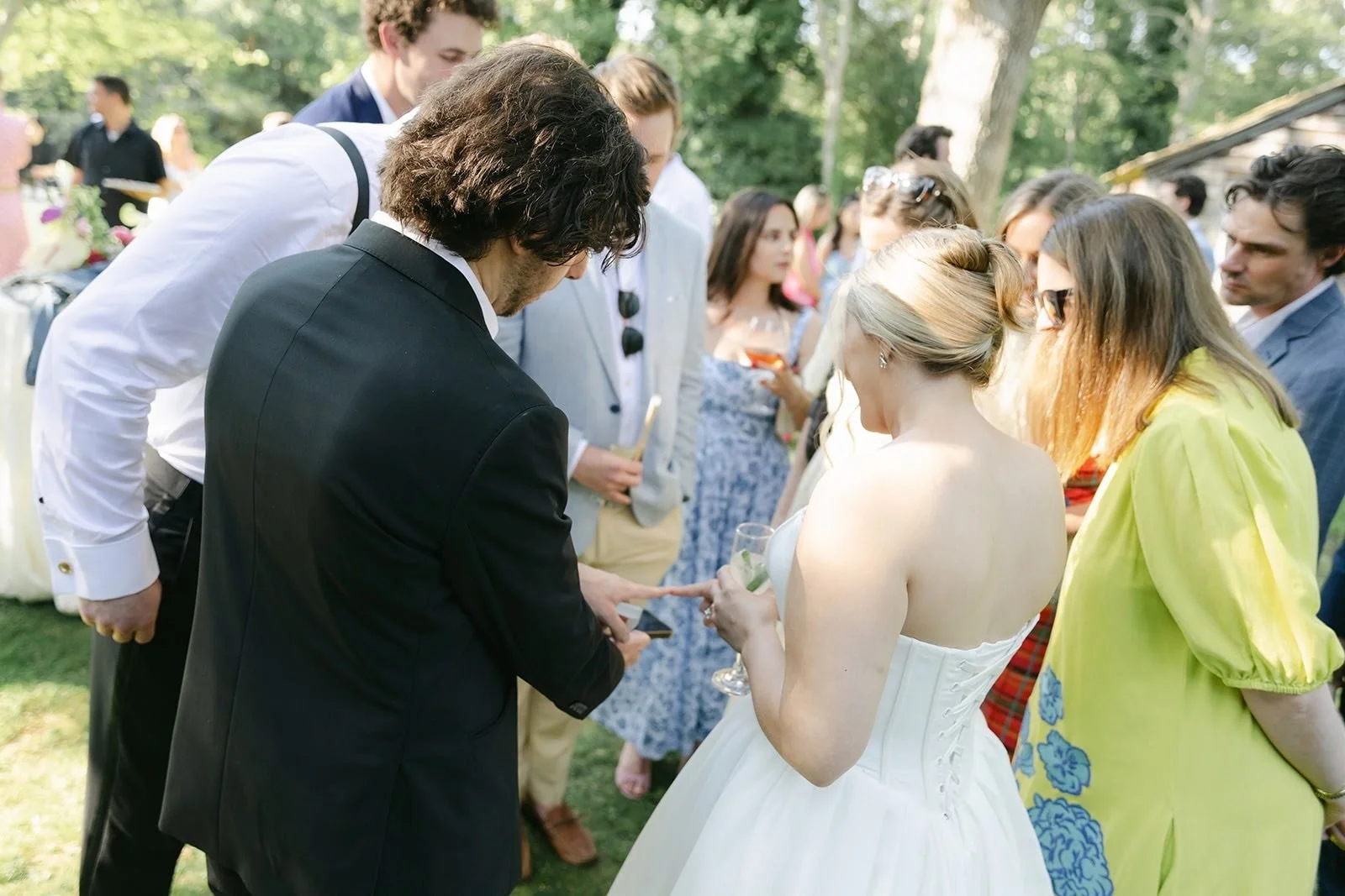 Boston wedding magician performing close-up magic for the bride and a circle of guests at cocktail hour