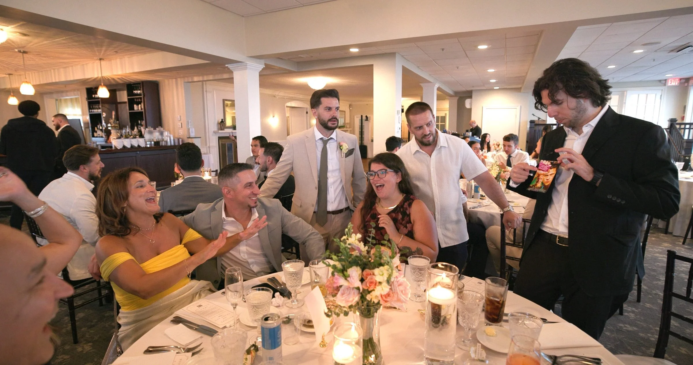Wedding guests laughing and reacting to a card reveal during a Rhode Island reception