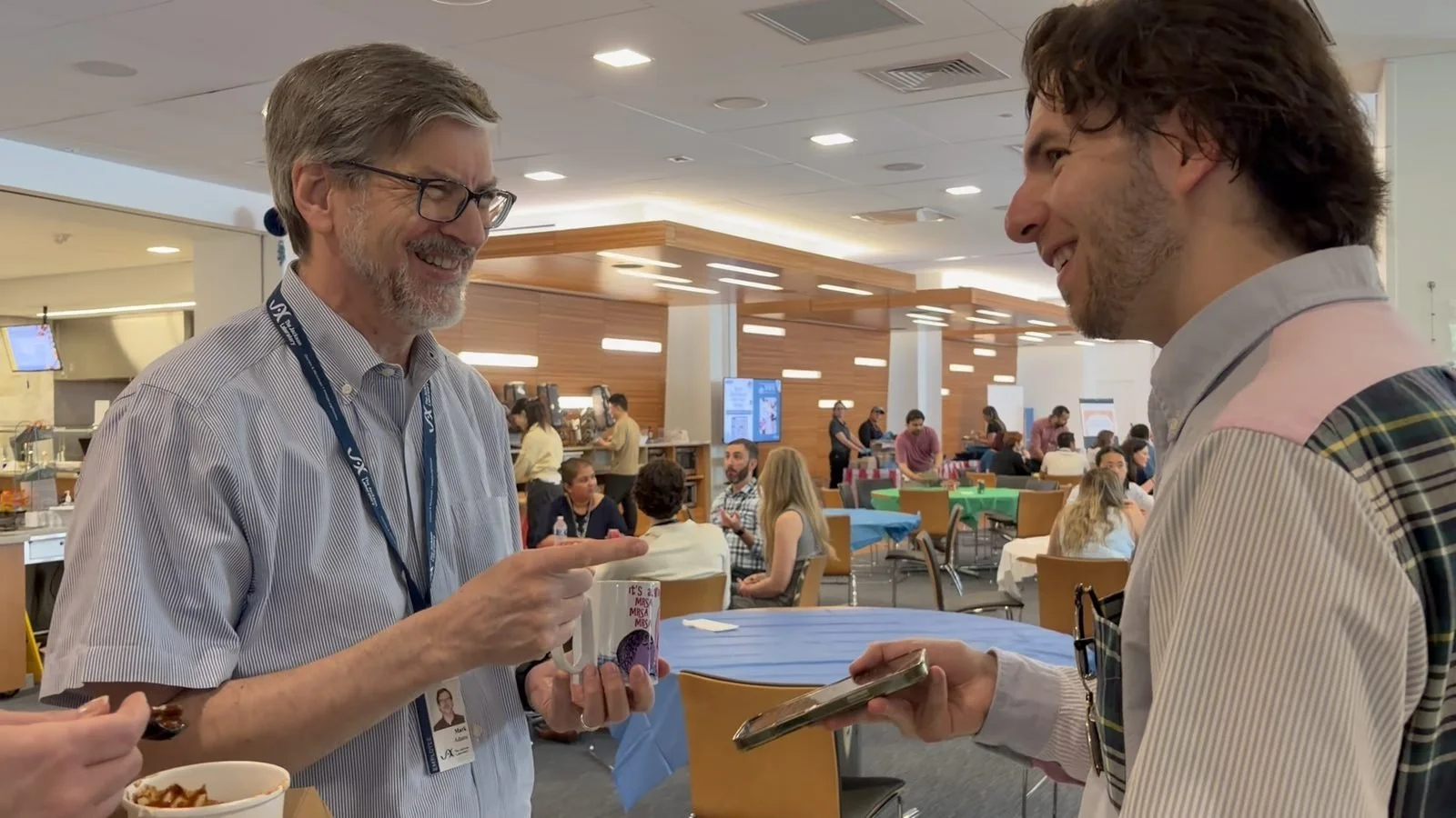 Colleagues laughing at a close-up magic trick during an employee appreciation event