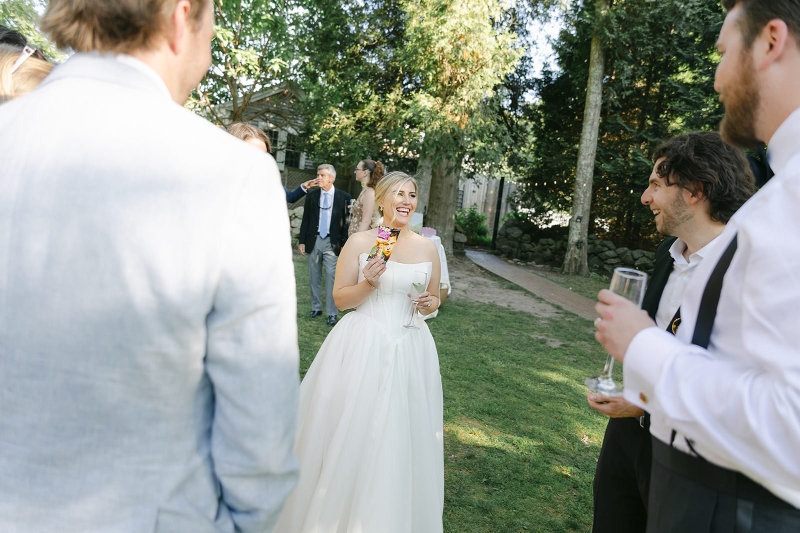 Bride holding a revealed playing card after a close-up magic trick at a Providence, Rhode Island wedding