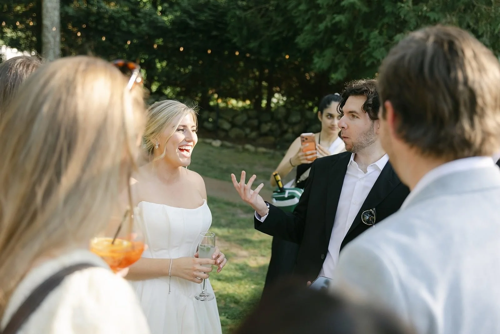 Bride laughing at a magic trick during a Cape Cod wedding cocktail hour