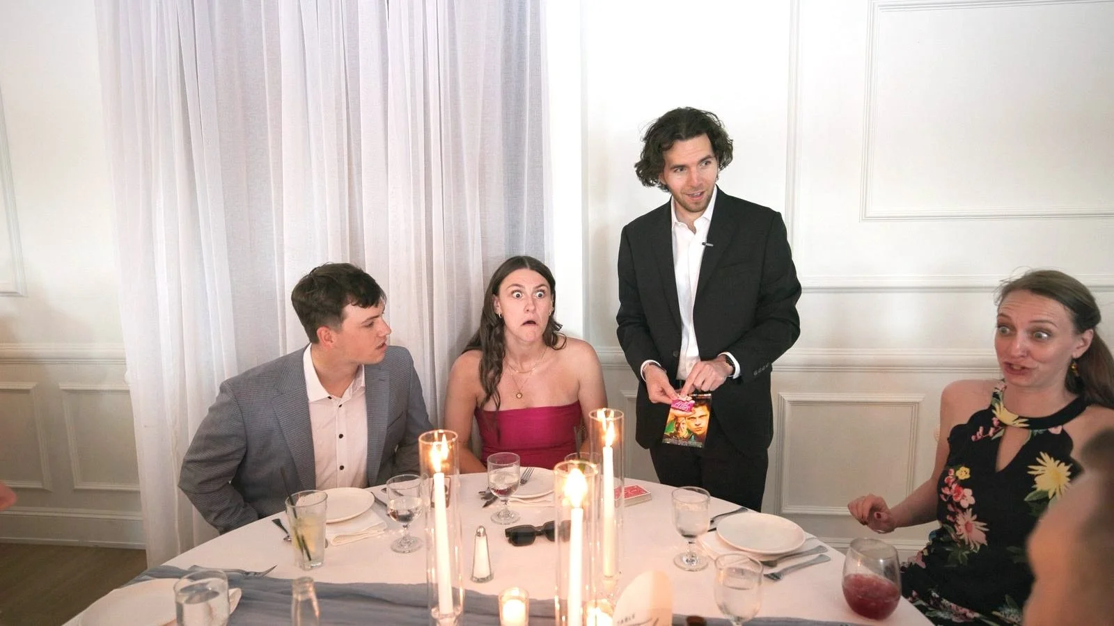 Guests reacting in surprise to a card reveal during a table-side performance at a Rhode Island dinner
