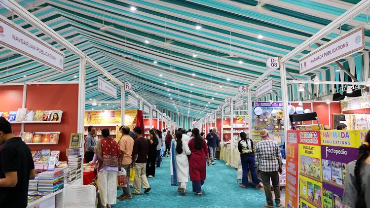 Visitors browsing publisher stalls along a festival aisle