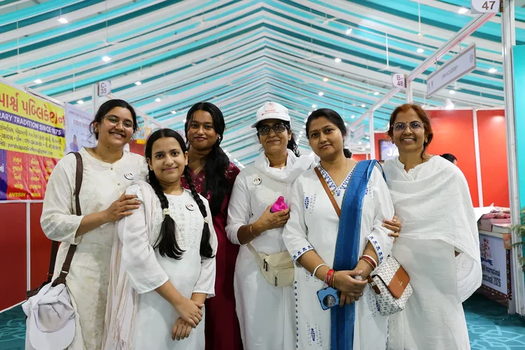 A group of women dressed in white smiling inside the festival hall