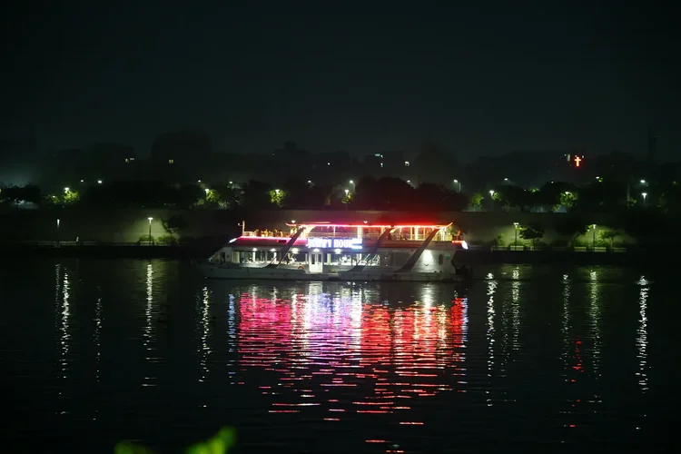 An illuminated boat reflected on the Sabarmati river at night