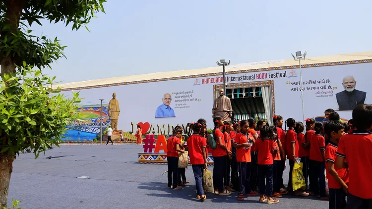 Schoolchildren in red uniforms gather outside the festival entrance
