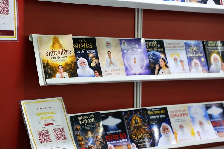 Hindi spiritual books displayed on a white shelf against a red wall