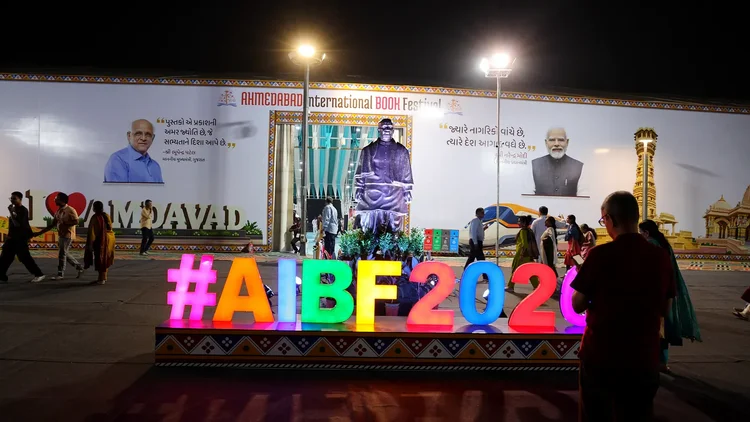 Glowing #AIBF2026 letters at the festival entrance at night