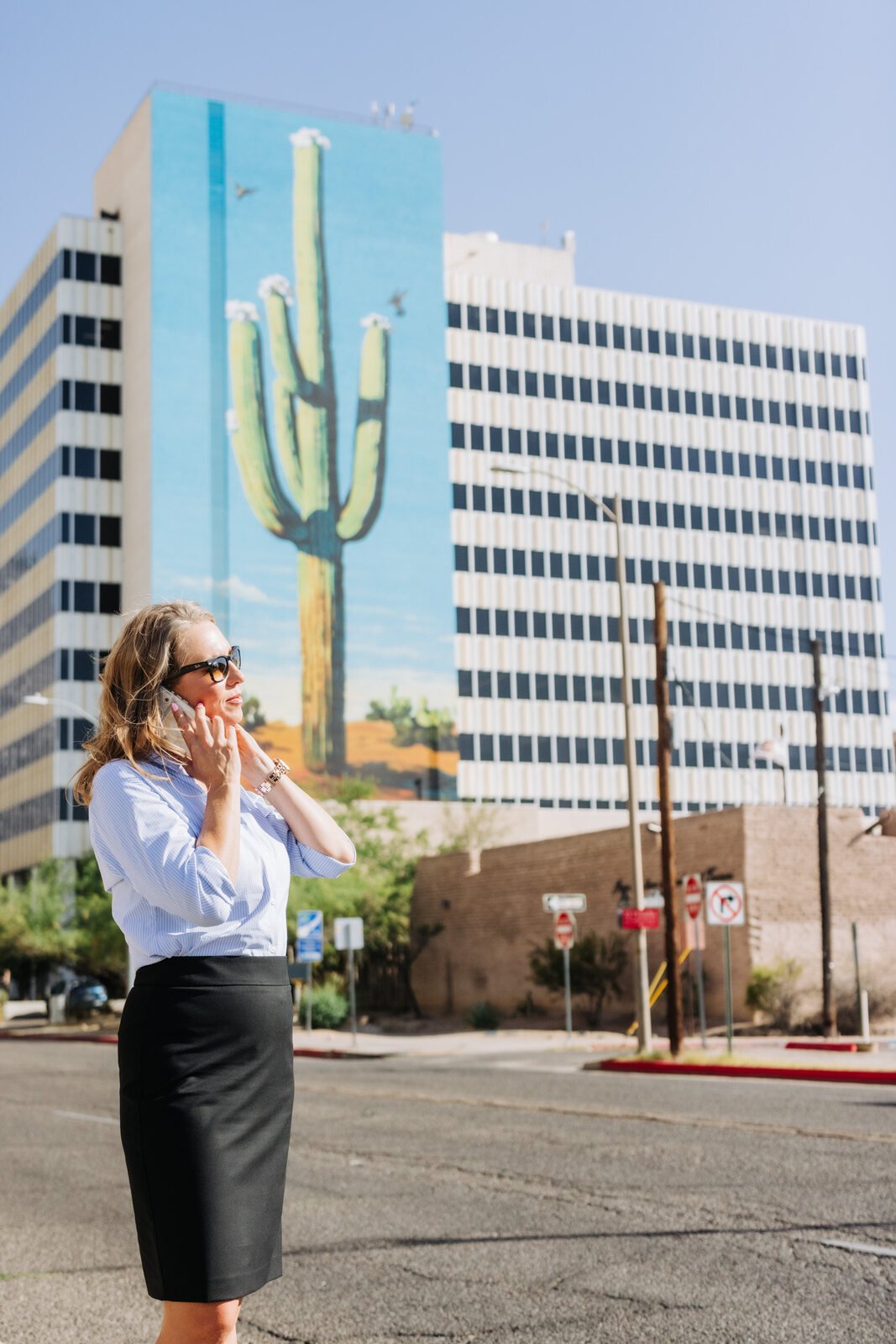 Amanda J. Bynum in downtown Tucson, with a saguaro mural in the background