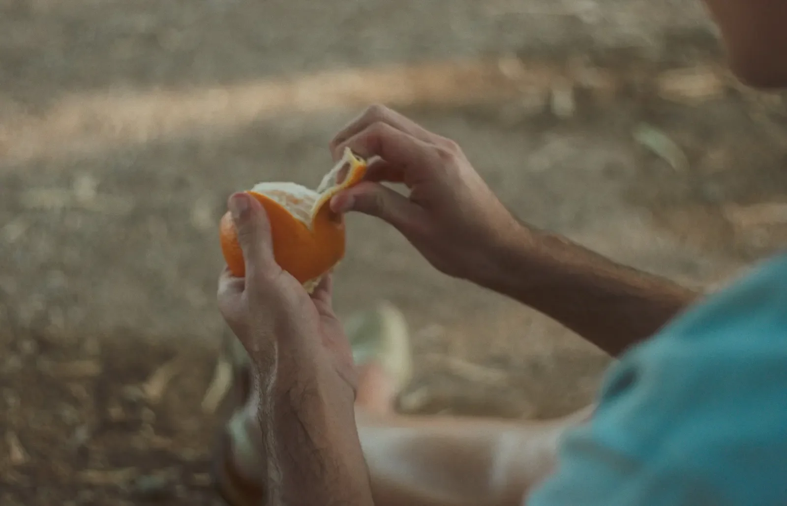 Manos pelando una naranja en un fotograma de Onades.