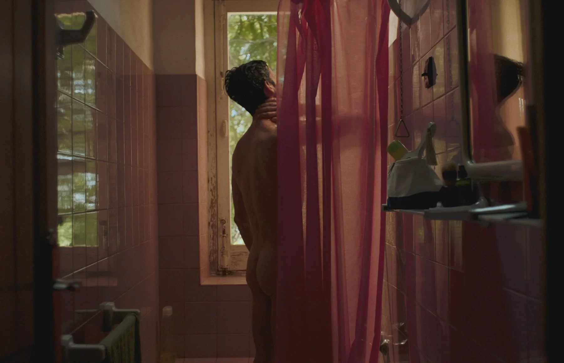 Álvaro en el interior de una casa, entre cortinas rojas.