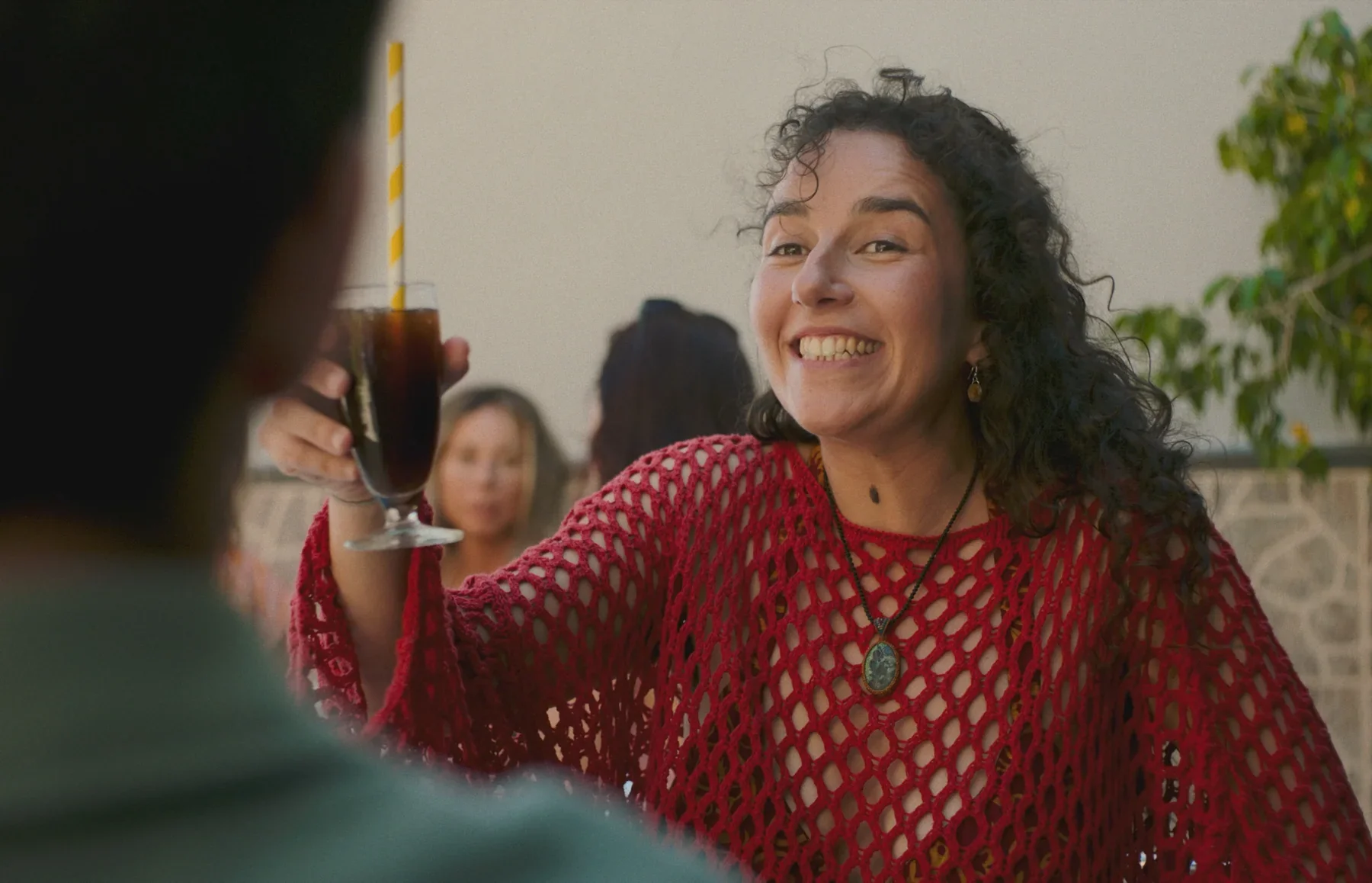 Paula sonríe levantando una copa.
