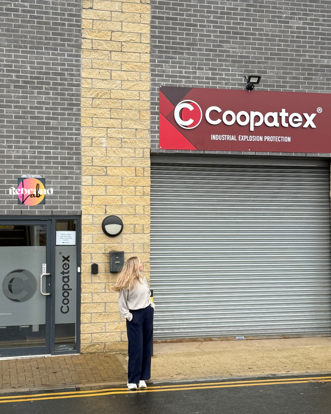 The designer standing in front of the finished Coopatex sign