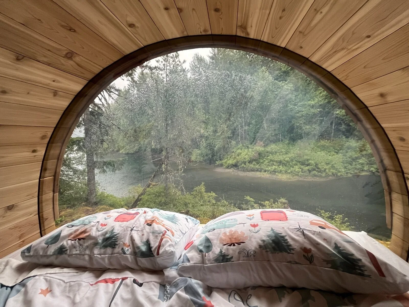View across the bed through the panoramic barrel window toward Sproat Lake