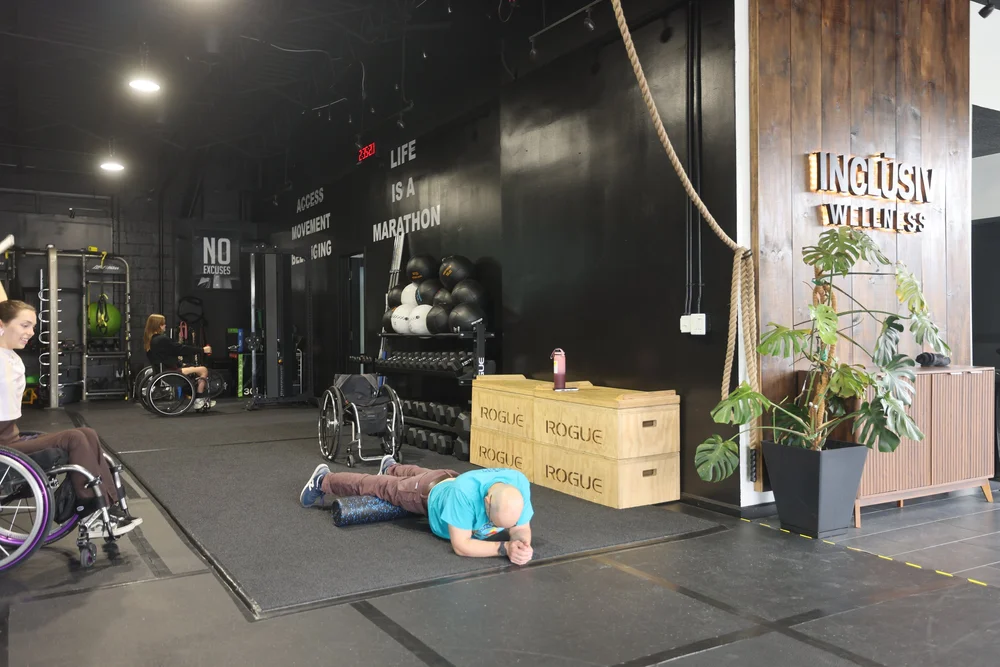 A member working on mobility with a foam roller on the gym floor