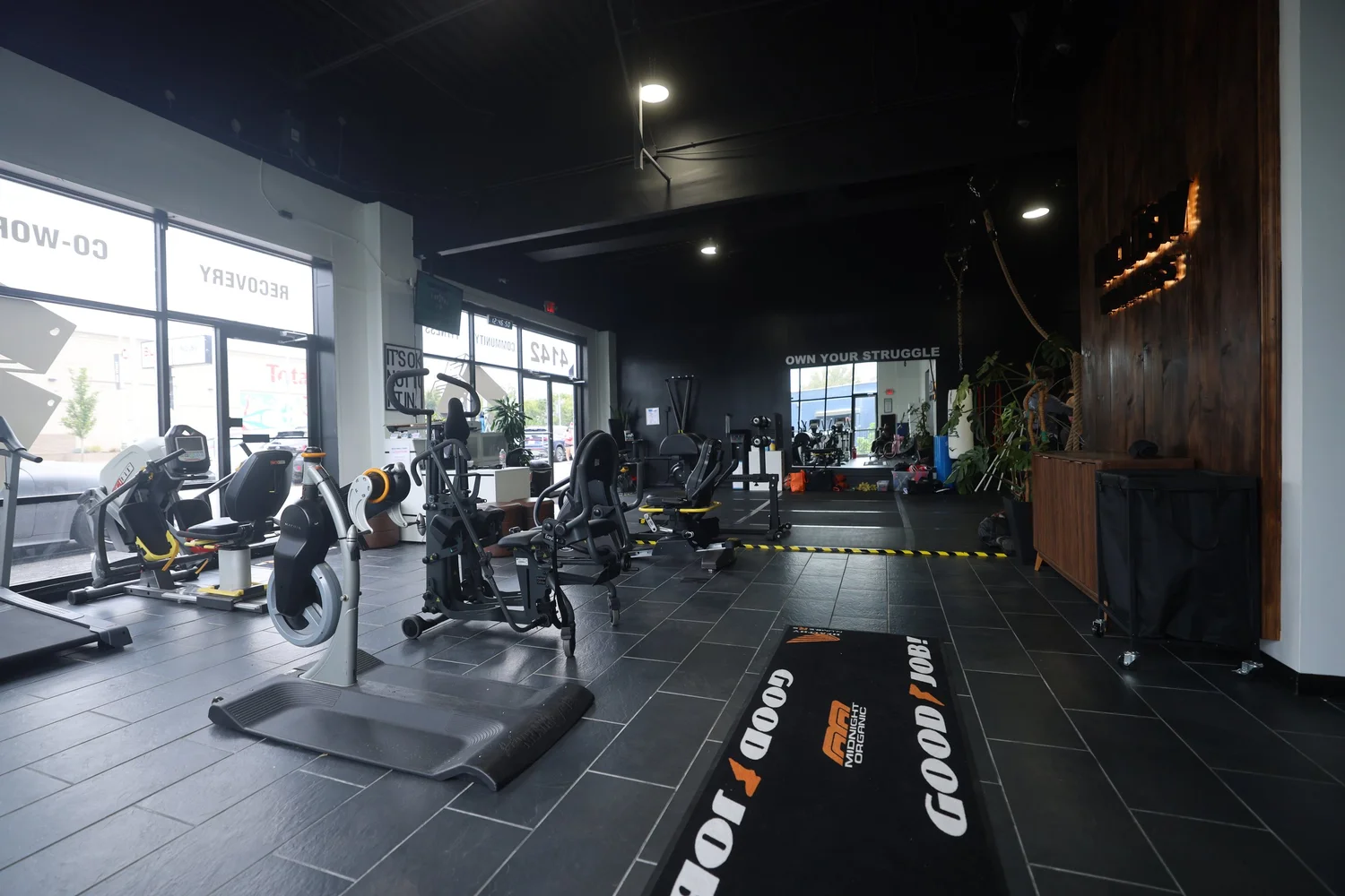 Cardio machines along the front windows at INCLŪSIV Wellness