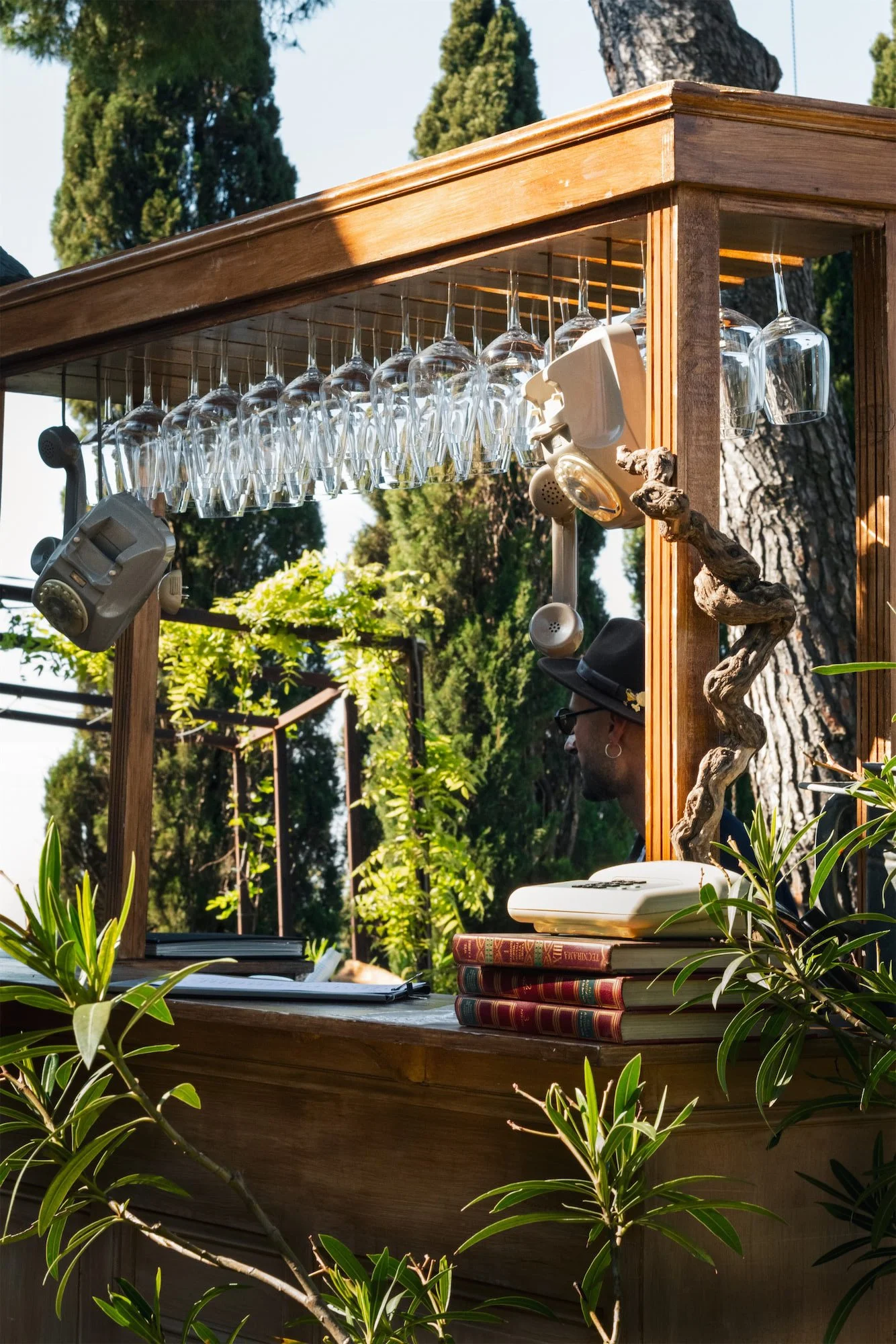 Postazione cocktail bar mobile per eventi i Fichi Catering: bancone in legno con bottiglie e bicchieri