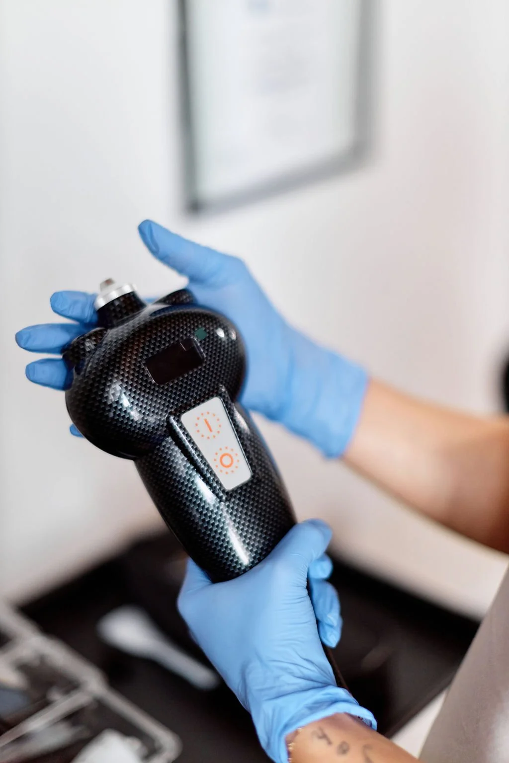 Gloved hands holding the SubZero cryotherapy handpiece