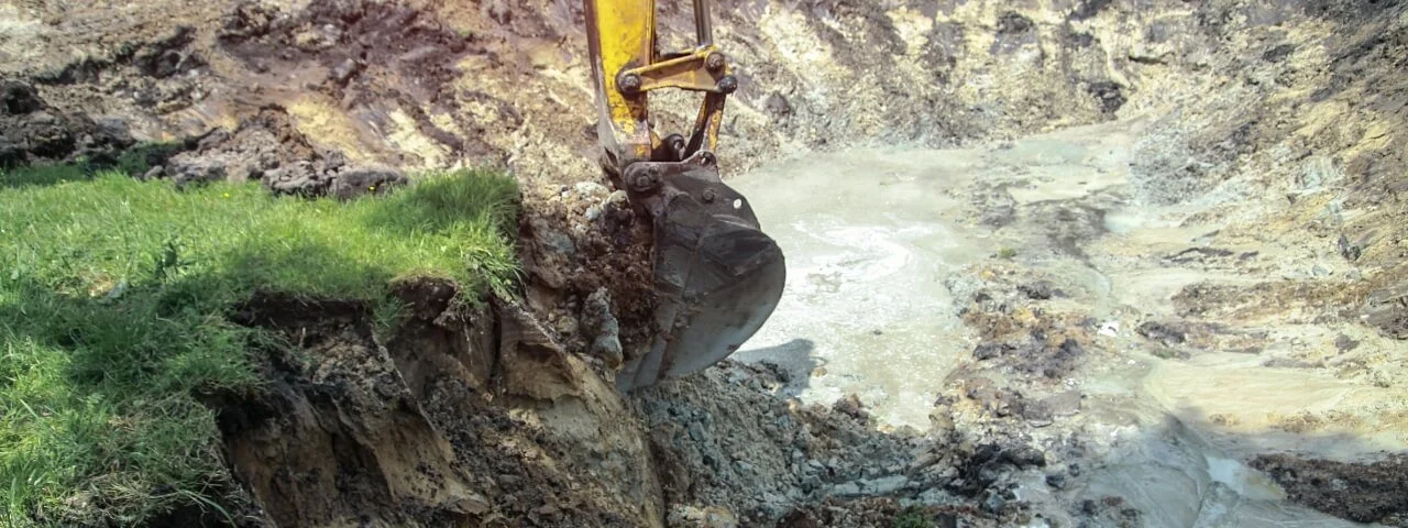 Excavator carrying out ground remediation and excavation works