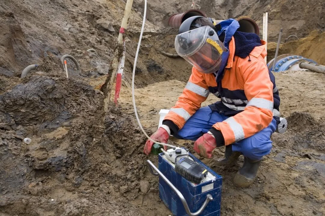 Engineer carrying out environmental sampling during a Phase 2 intrusive site investigation