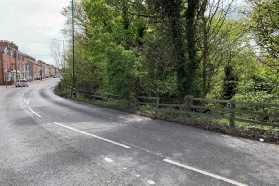 A174 at Loftus Bank beside the steep wooded valley-side slope