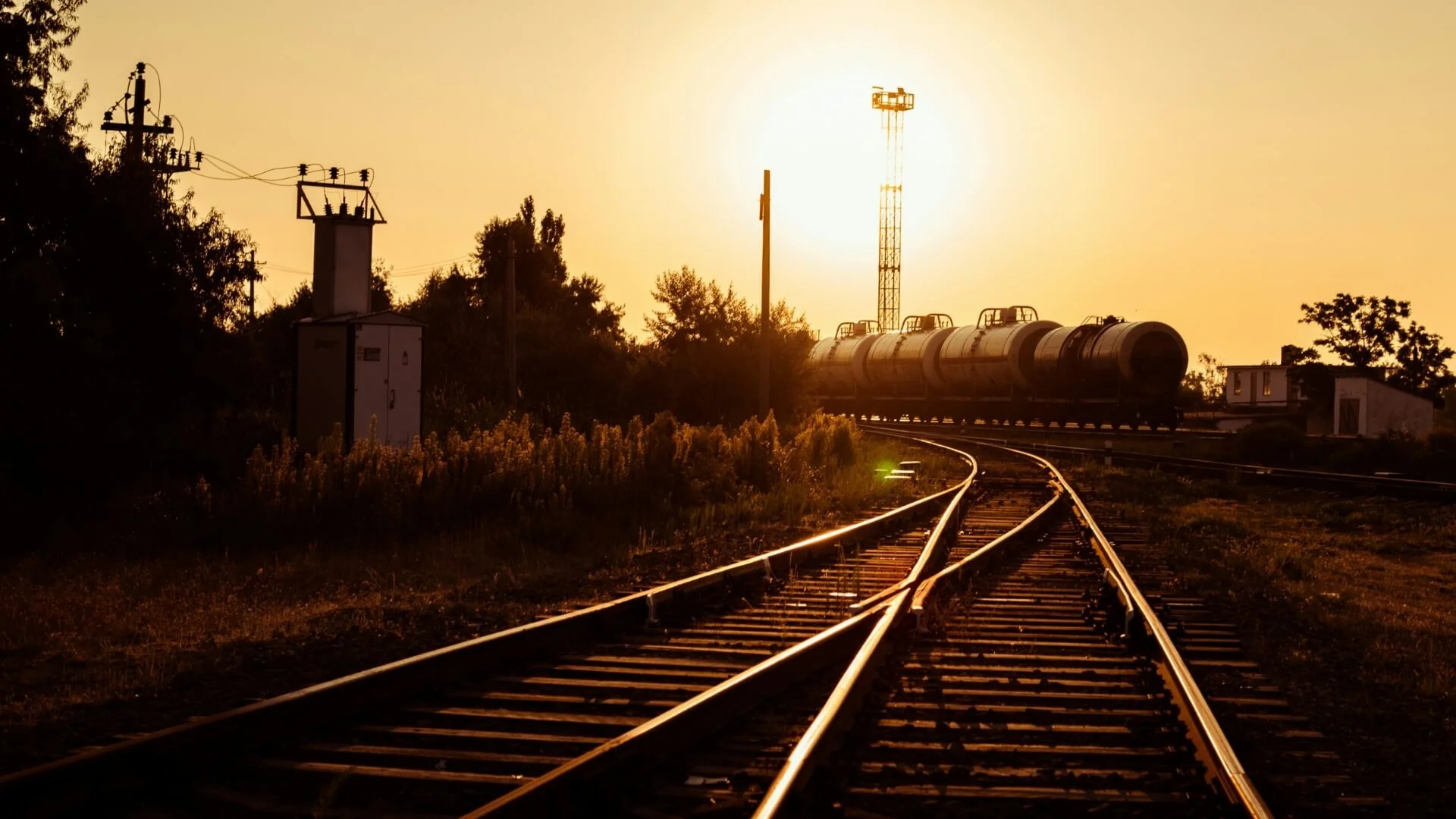Railway tracks and industrial rail infrastructure at sunset
