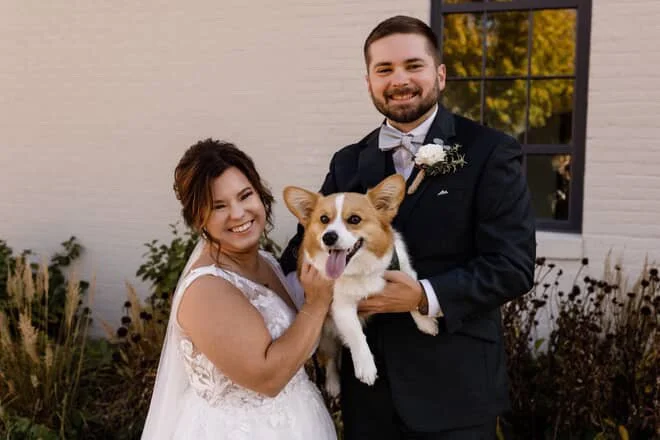 Couple with their corgi on their wedding day