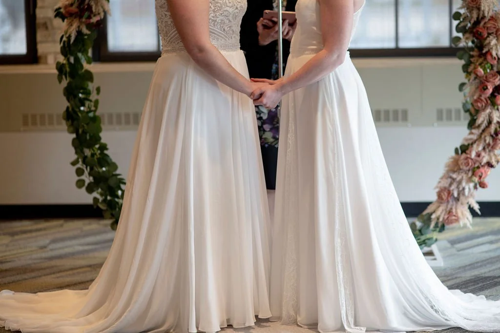 Two brides holding hands