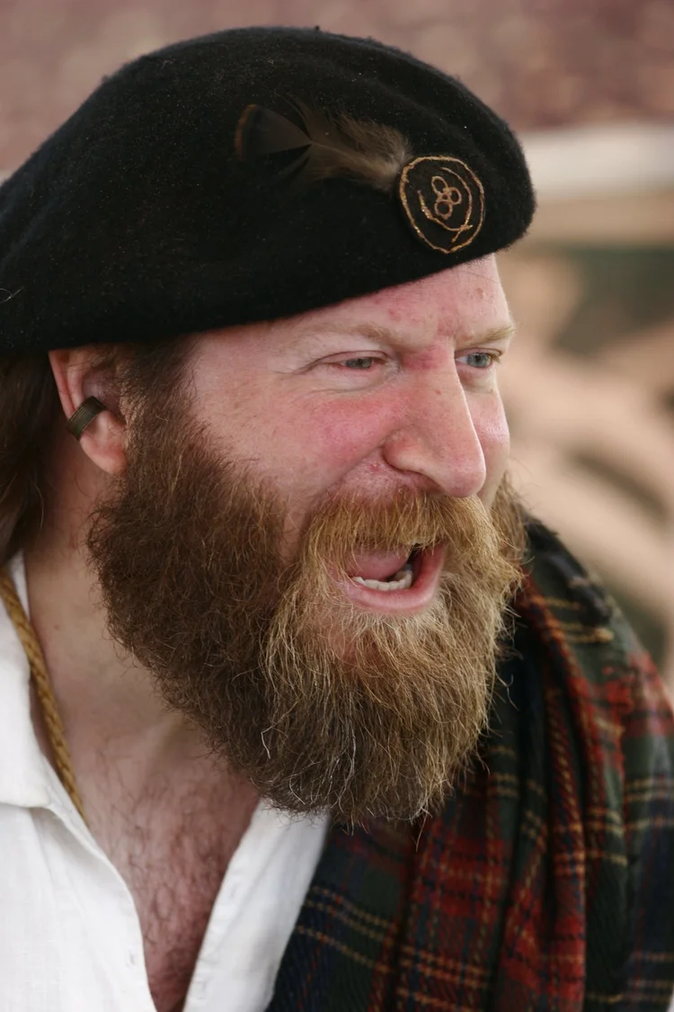 Bearded man in a beret and tartan