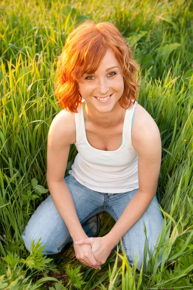 Red-haired young woman in tall grass