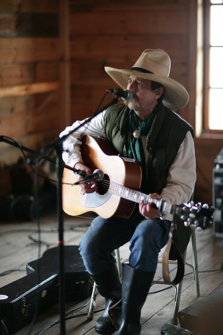 Singer with an acoustic guitar on a small stage