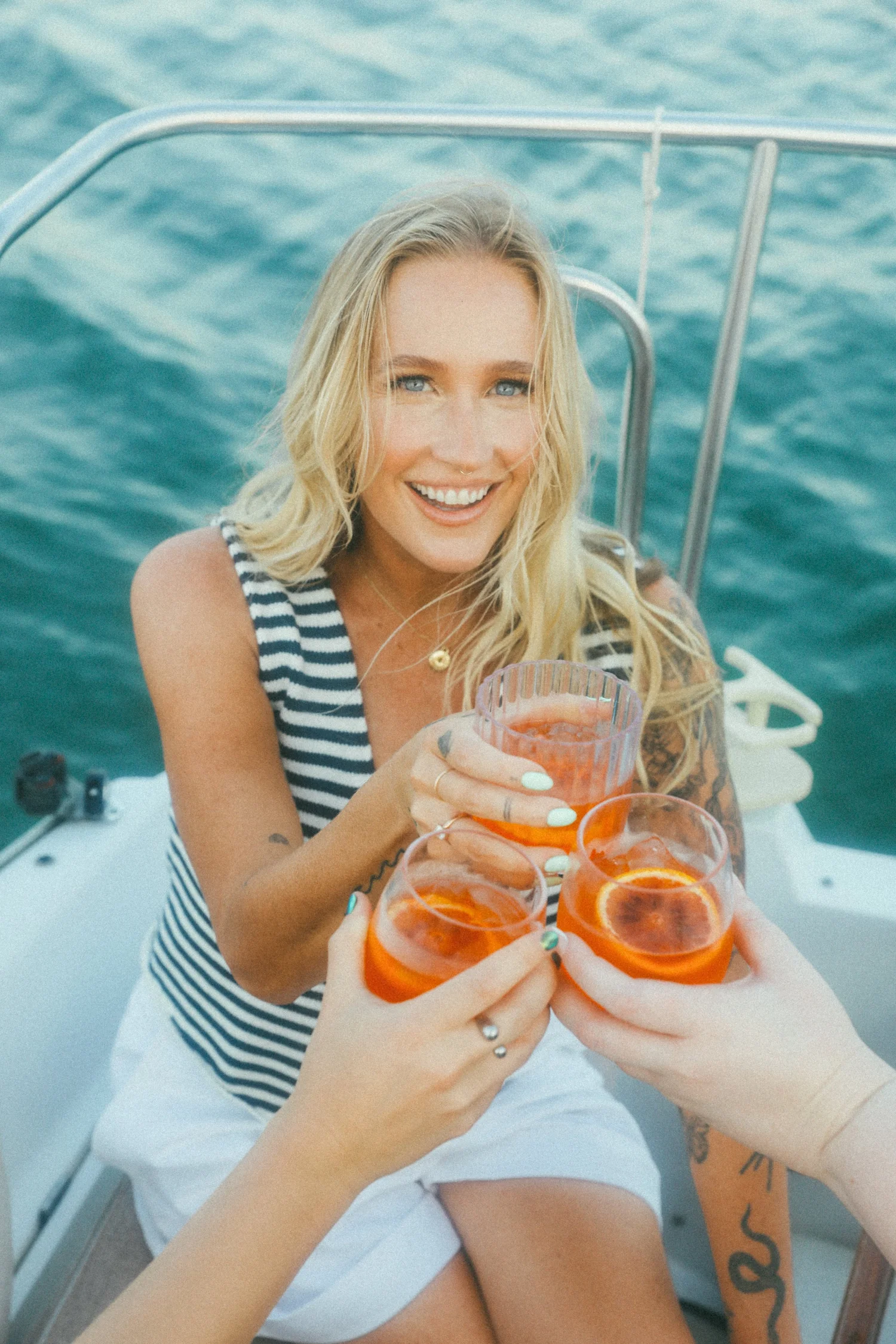 Krista Ripma on a boat, raising a spritz