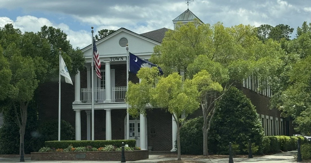 Summerville Town Hall, a brick building with white columns, with the American and South Carolina flags out front