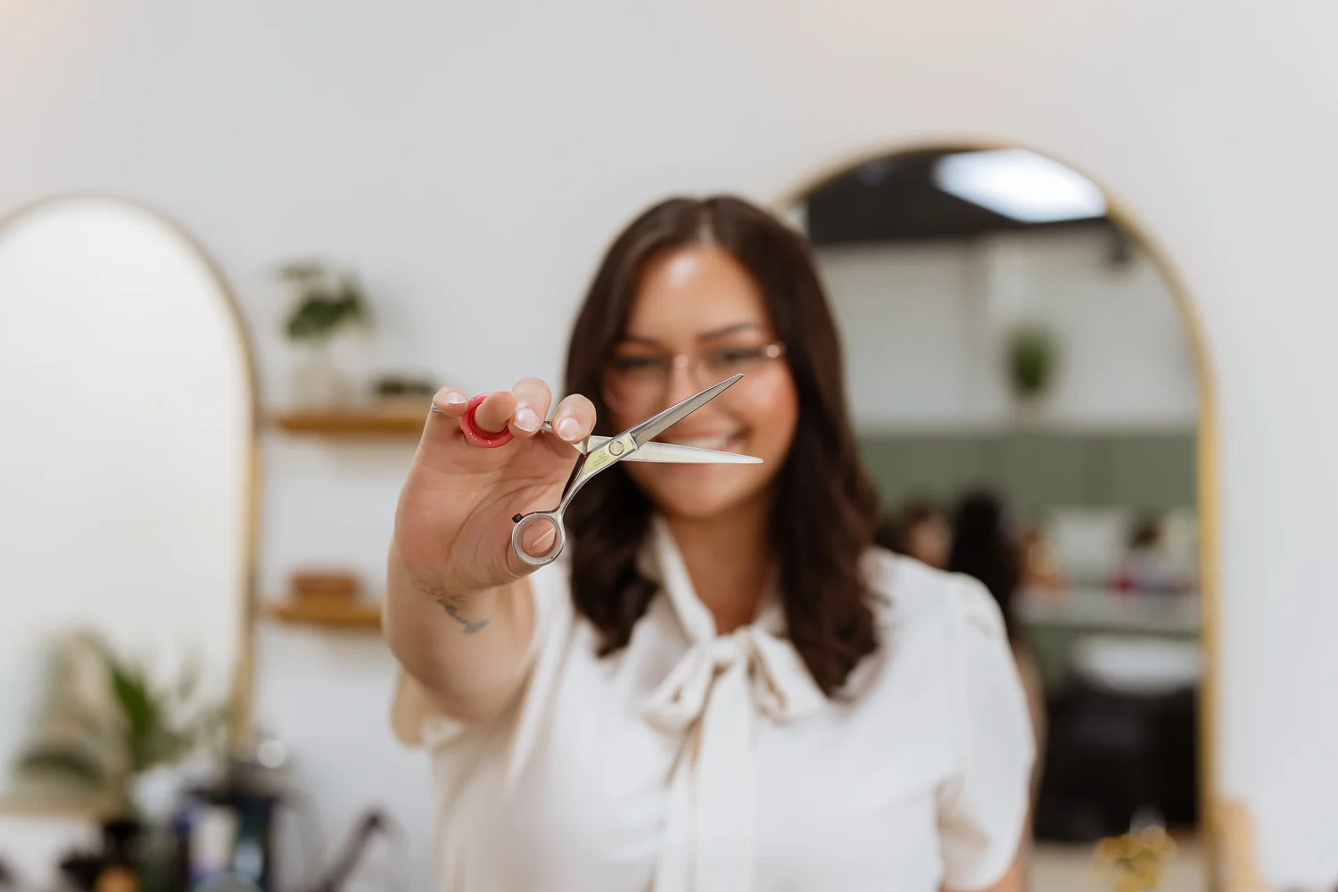 Stylist with shears ready for a haircut at Heads You Win Salon