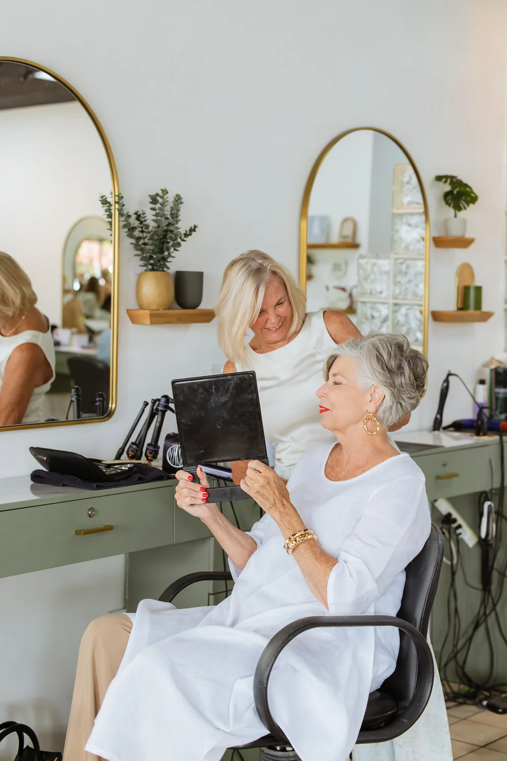 Client admiring her new color in a hand mirror