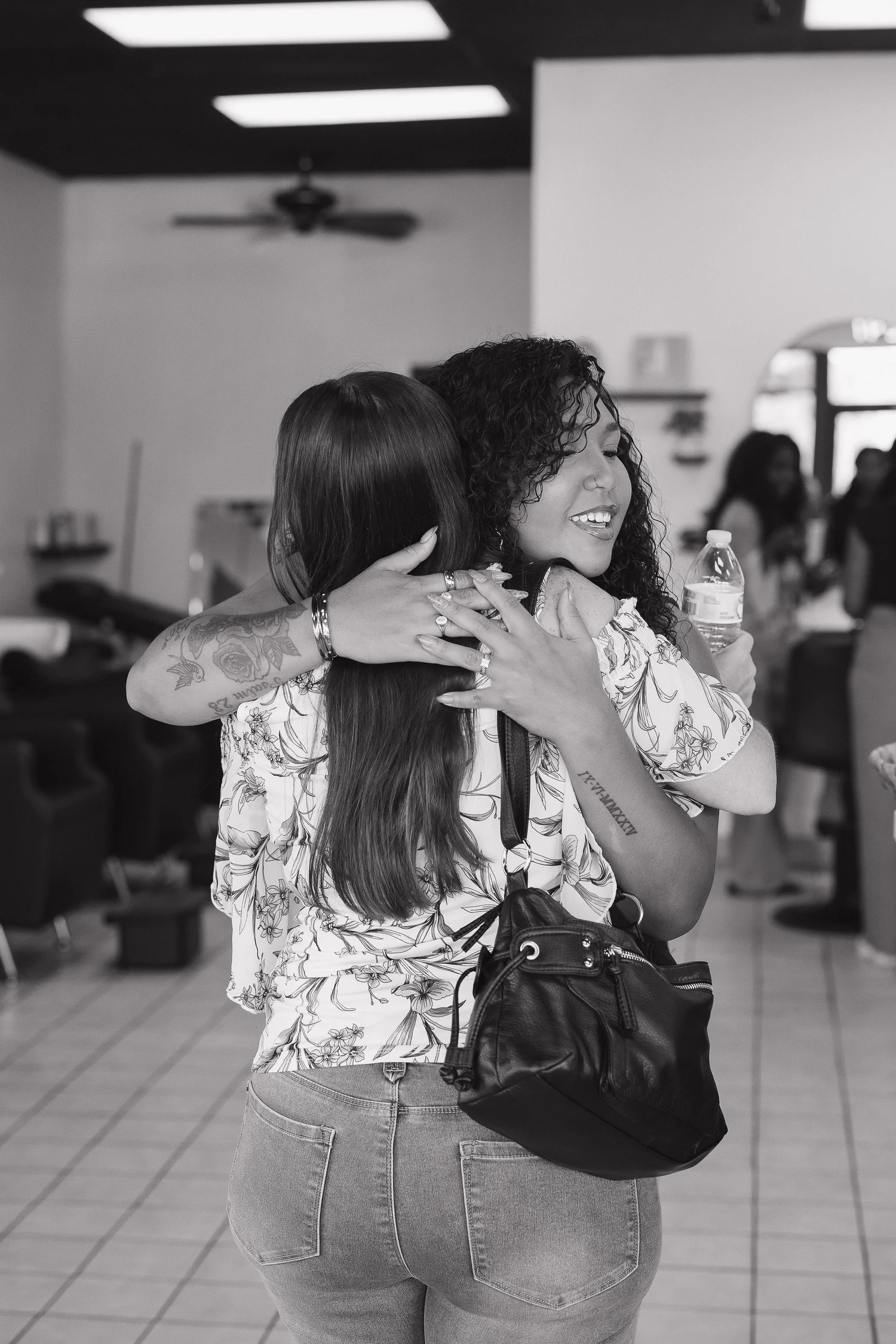Erica hugging a happy client at Heads You Win Salon