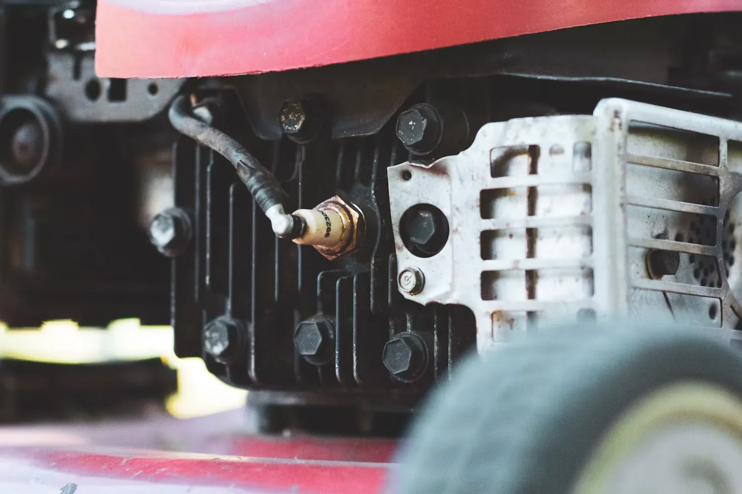 Close-up of a lawn mower engine and spark plug