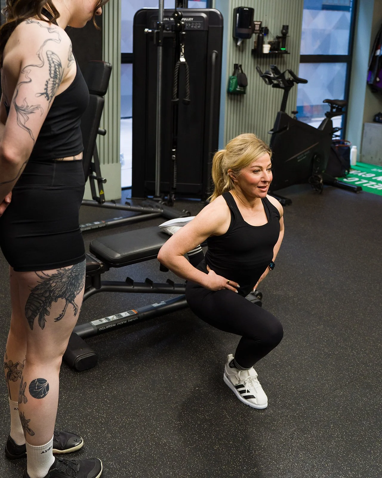 Nicolina coaching a client on performing a leg exercise