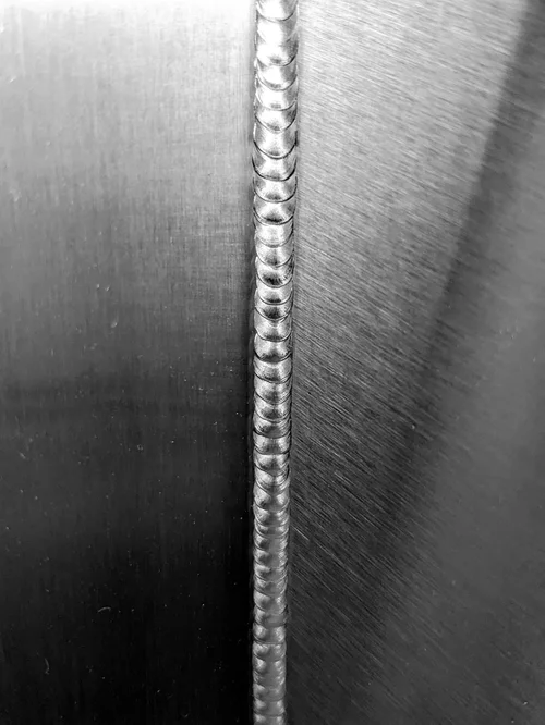 Close-up of a hand-welded seam in the stainless steel