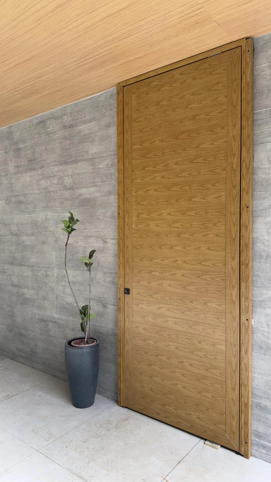 Porta pivotante de madeira em parede revestida com Wall Skin