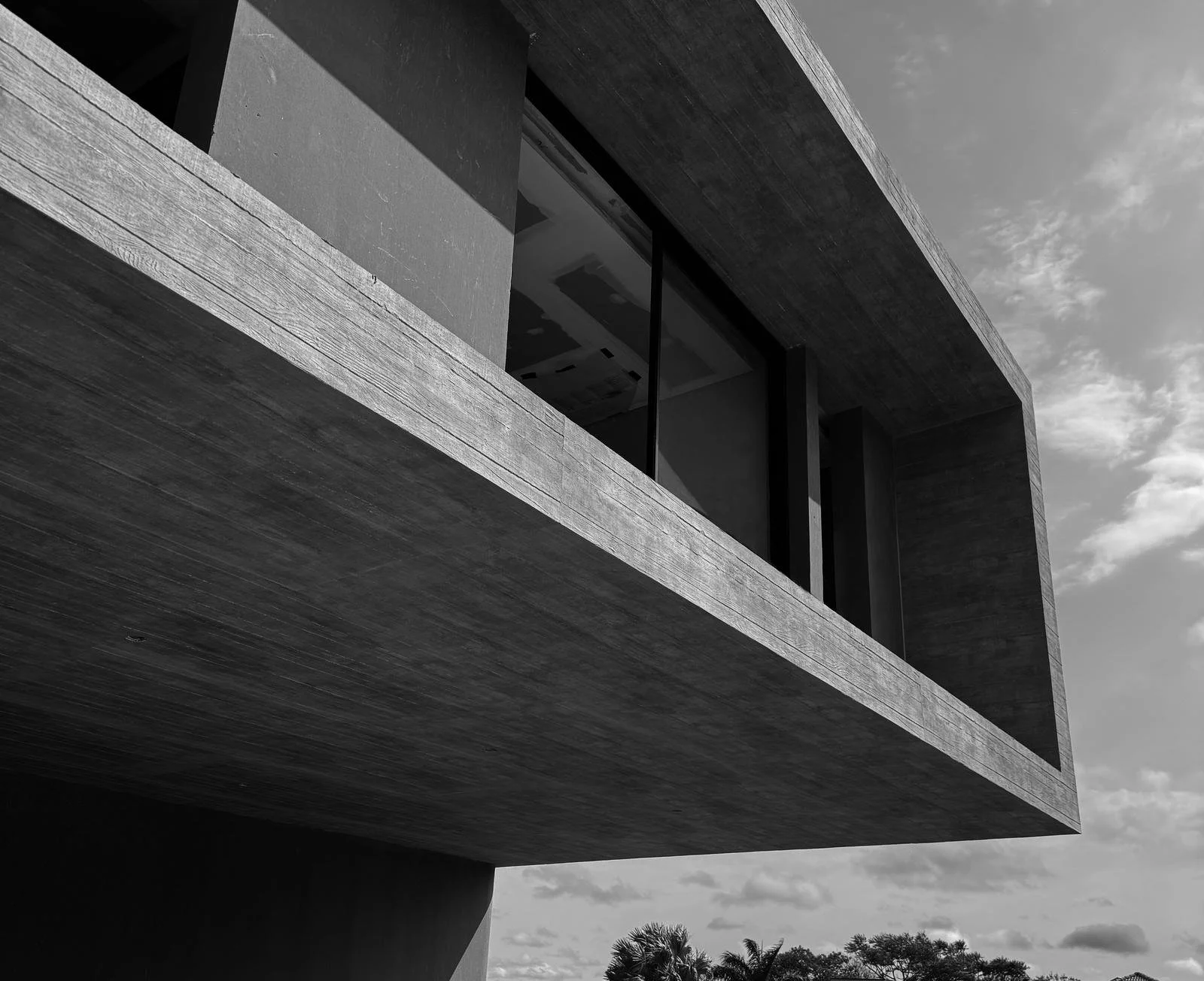 Volume em balanço de concreto aparente, em preto e branco